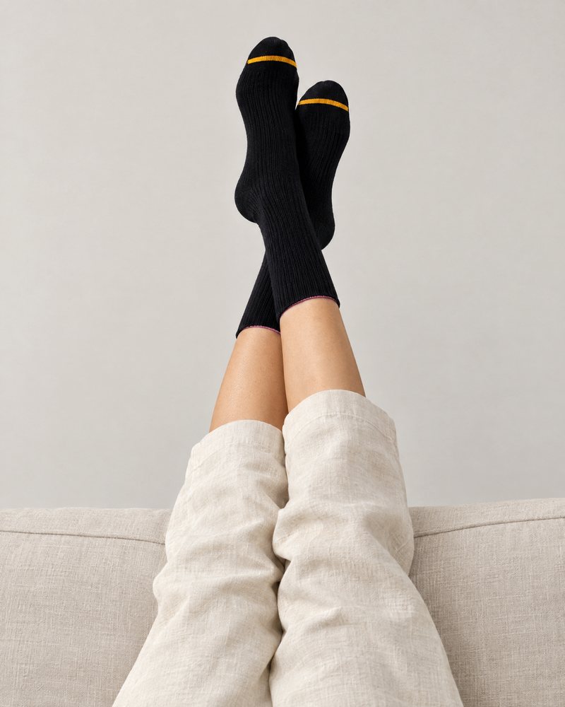 Black pair worn at home, feet crossed and raised up on the sofa