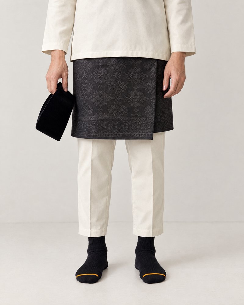 Black pair worn with baju Melayu and samping, songkok in hand, ready for the surau