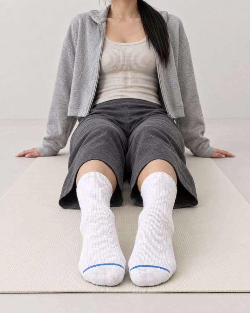 White pair worn after yoga, seated on a mat